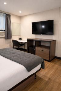 a hotel room with a bed and a flat screen tv at Cabana Hotel Yankee Stadium in Bronx