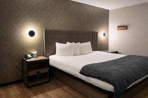 a hotel room with a large bed with white pillows at Cabana Hotel Yankee Stadium in Bronx
