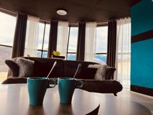 a living room with a couch and two mugs on a table at L&A Apartments in Dragash +25 photos