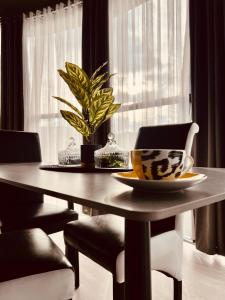 a dining room table with a plate and a plant on it at L&A Apartments in Dragash