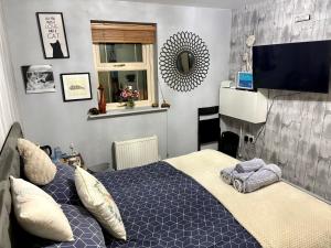 a bedroom with a bed and a flat screen tv at The Purrfect Creative Retreat in Gainsborough