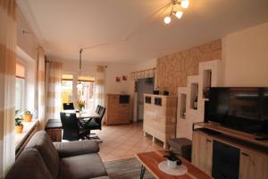a living room with a couch and a tv and a table at Haus Clara in Husby