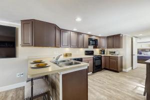 a kitchen with wooden cabinets and a counter top at 12 Mi to Lake George! Quiet Adirondack Escape in Fort Ann