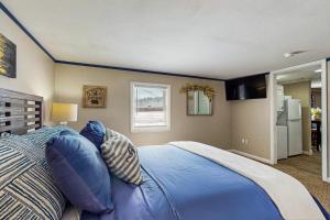 a bedroom with a large blue bed with blue pillows at 12 Mi to Lake George! Quiet Adirondack Escape in Fort Ann