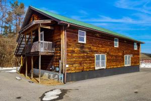 a log cabin with a balcony on the side of it at 12 Mi to Lake George! Quiet Adirondack Escape in Fort Ann