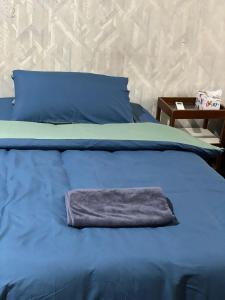 a blue bed with a towel on top of it at PAMA'Pranakorn in Bangkok