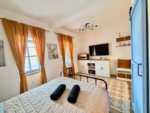 a bedroom with a bed with two black objects on it at Kökény Kunyhó in Kisszékely