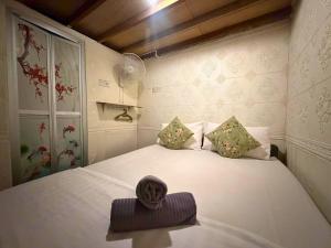 a bedroom with a white bed with a hat on it at Dou Houz Georgetown in George Town +81 photos