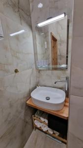 a bathroom with a white sink and a mirror at Boudoir-Art Studio Apartment in Debrecen +16 photos