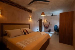 a bedroom with a bed and a blue chair at Casa Maradi-Arena in Mazunte