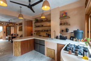 a kitchen with wooden cabinets and a stove top oven at Casa Maradi-Arena in Mazunte +13 photos