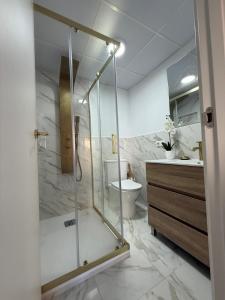 a bathroom with a shower and a toilet and a sink at Duplex Ático con terraza y BBQ in Puerto de Sagunto +14 photos
