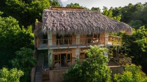 a house with a thatched roof in the trees at Casa Maradi-Arena in Mazunte