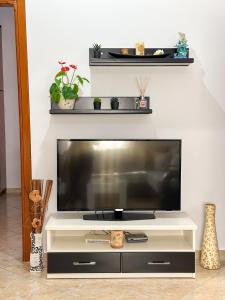 a flat screen tv sitting on top of a white entertainment center at Xhoni's House in Sarandë