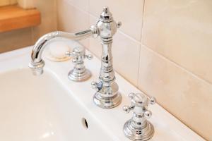 a bathroom sink with two faucets on it at La Meridiana in Carrù