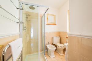 a bathroom with a toilet and a glass shower at La Meridiana in Carrù