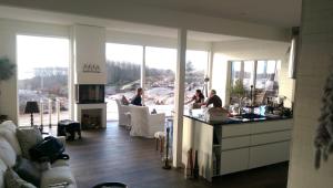 a kitchen with two women sitting at a counter in a house at Utsikten i Bua in Kungshamn