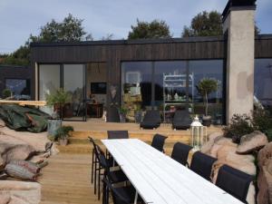 a long wooden table and chairs in a patio at Utsikten i Bua in Kungshamn