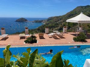 a man swimming in a swimming pool with a view of the ocean at La Palma “Villa Nunzia” in Serrara Fontana