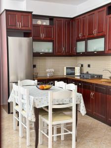 a kitchen with wooden cabinets and a table and chairs at Xhoni's House in Sarandë