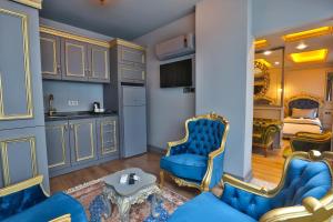 a living room with blue chairs and a kitchen at REAL KiNG SUiTE in Trabzon