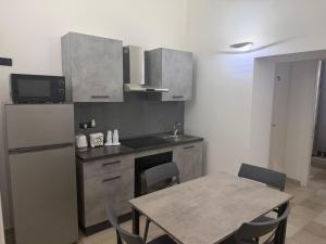 a kitchen with a table and a refrigerator at Antica Dimora in Taranto