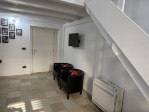 a living room with two chairs and a tv at Antica Dimora in Taranto