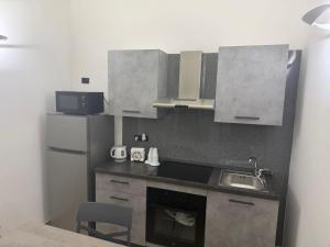 a small kitchen with a sink and a refrigerator at Antica Dimora in Taranto +13 photos