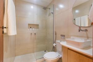 a bathroom with a shower and a toilet and a sink at Onda Lofts in Búzios +27 photos