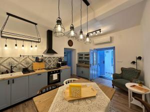 a kitchen and living room with a table and a dining room at Kökény Kunyhó in Kisszékely