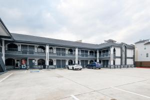 a building with a car parked in a parking lot at Downtowner Inns - Houston Downtown & Convention Center in Houston