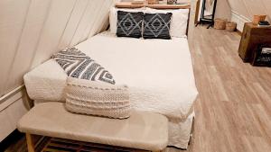 two beds in a small room with a chair at Forget Me Not Aframe-Cave Run in Wellington