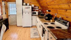 a kitchen with a white refrigerator and a stove at Forget Me Not Aframe-Cave Run in Wellington