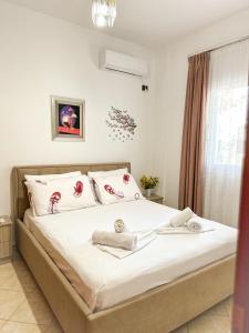 a bedroom with a large white bed with towels on it at Xhoni's House in Sarandë