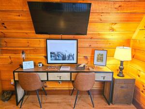 a desk with two chairs and a computer on it at Forget Me Not Aframe-Cave Run in Wellington