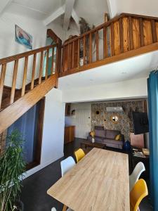 a living room with a wooden table and a staircase at La splendide Coralline in La Saline Les hauts 