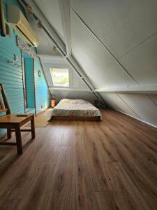 a attic room with a bed and a wooden floor at La splendide Coralline in La Saline Les hauts  +24 photos