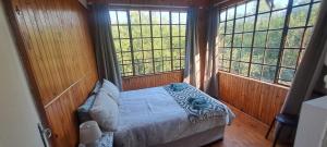 a bedroom with a bed in a room with windows at Ratel Retreat in Marloth Park +18 photos