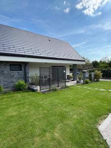 a house with a green lawn in front of it at PIHE apartmanok in Balatonfüred