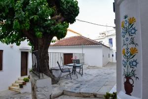 a table and chairs under a tree in a courtyard at Stella's House in Skopelos Town