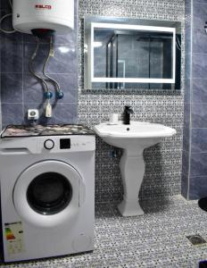 a bathroom with a washing machine and a sink at Stella's House in Skopelos Town +2 photos