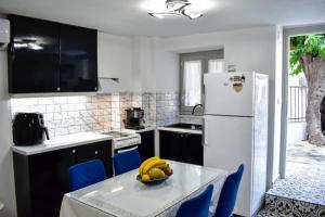 a kitchen with a table with a bowl of bananas on it at Stella's House in Skopelos Town