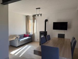 a living room with a table and a couch at Gîte 2 suites proche du lac de Chalain in Montigny-sur-lʼAin