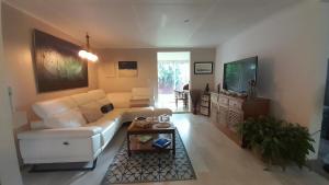 a living room with a white couch and a tv at La Kaz Zarlor in Saint-Paul