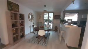 a kitchen and dining room with a table and a counter at La Kaz Zarlor in Saint-Paul