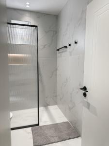 a shower with a glass door in a bathroom at Xhoni's House in Sarandë +33 photos