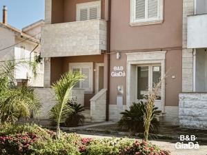 a pink building with plants in front of it at B&b Giadà in Avetrana