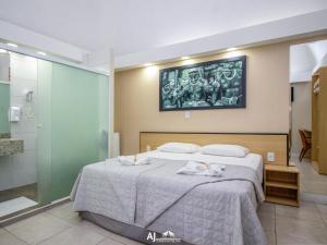a bedroom with a bed with towels on it at AJ TERMAS HOTEL IRAÍ in Iraí
