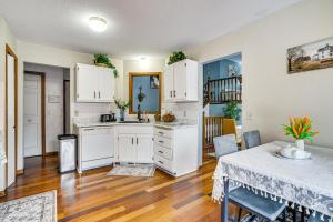 a kitchen with white cabinets and a table in a room at Deck & Outdoor Dining! Spacious St Paul Getaway in North Saint Paul +21 photos