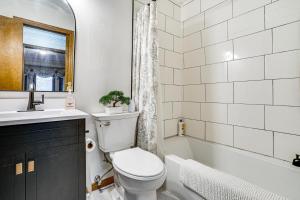 a bathroom with a toilet and a sink and a tub at Deck & Outdoor Dining! Spacious St Paul Getaway in North Saint Paul